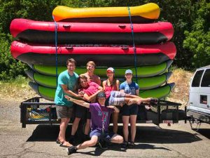 River guides posing in front of rafts and kayaks before a river trip on the Provo River, Provo Utah.